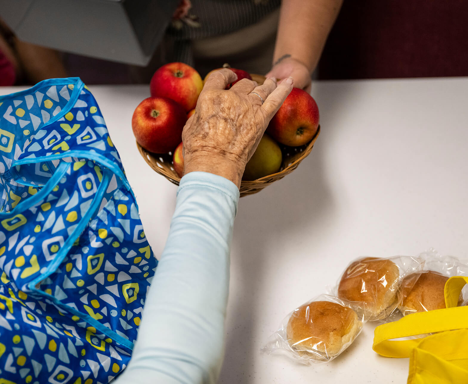 Woman giving apple to elderly